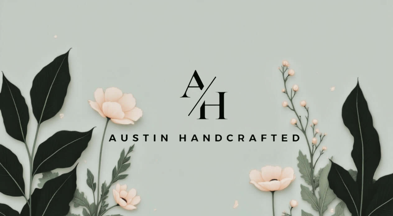 sage green background with pale clay pastel colored flowers and dark greenery surrounds the Austin Handcrafted logo, inspired by their handcrafted, all-natural products 